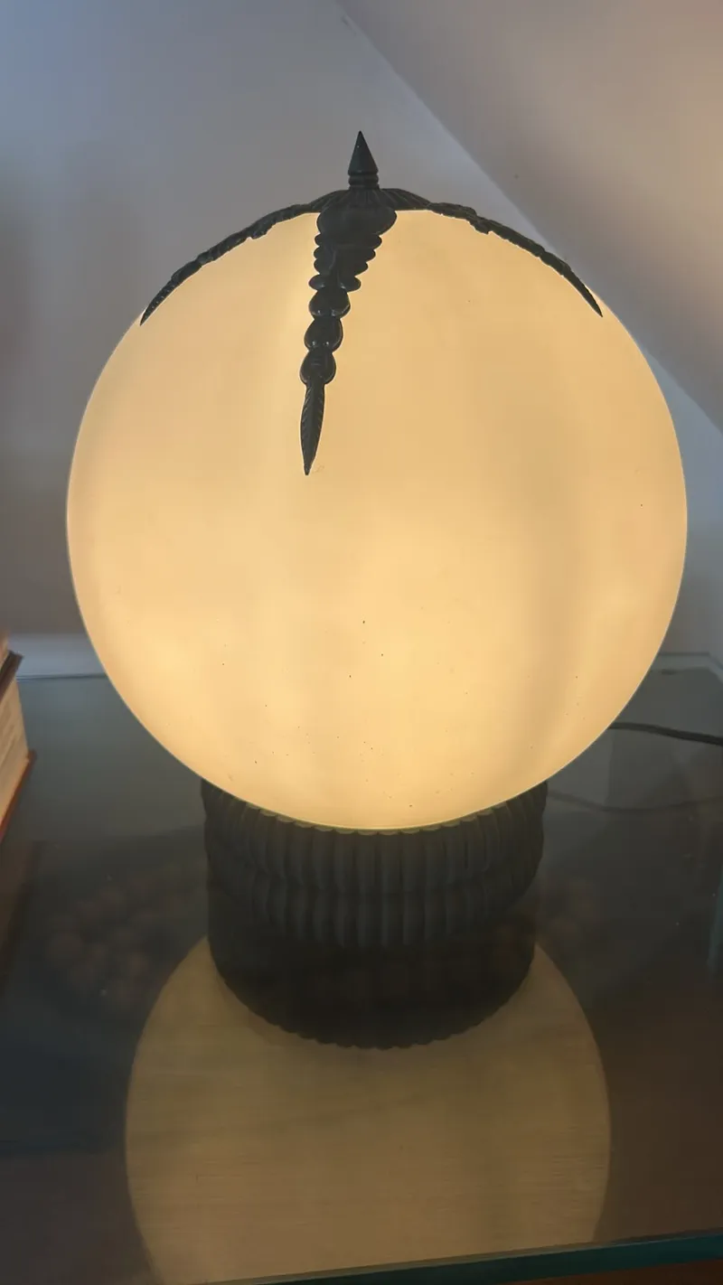 Luminária esfera de luz quente com detalhes escuros e base canelada